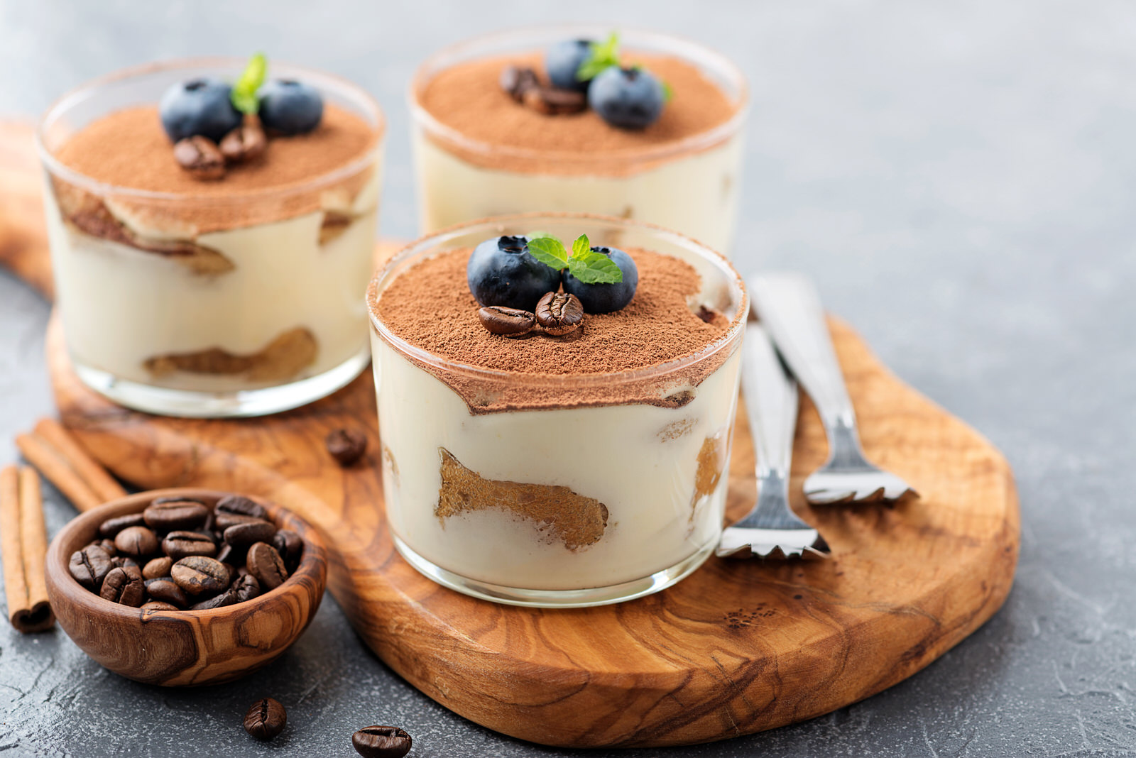 Chocolate Making Course – Tiramisu dessert in a glass topped with chocolate and two blueberries with green leaves.