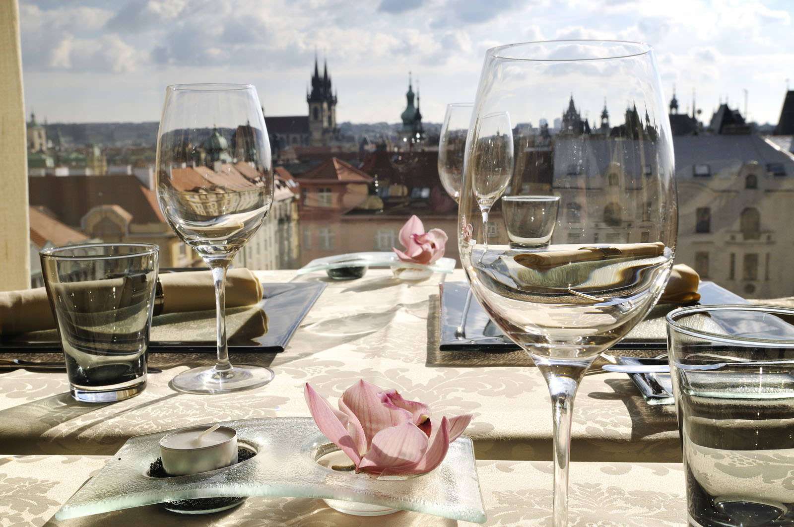 A restaurant terrace with a beautiful view of Prague, with the towers of the Týn Church in the background.